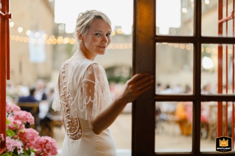 Smiling Bride Graces Grand Chateau Entrance in Auch, France Bridal portrait at a French chateau: the bride smiles from the doorway of a grand Auch venue.