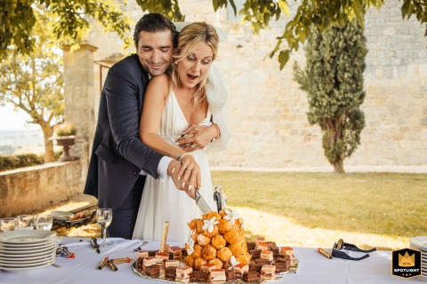 Cutting the Wedding Cake at Chateau de Flamarens, France Bride and groom joyfully cut their wedding cake at Chateau de Flamarens, Gers, France, celebrating their special day.
