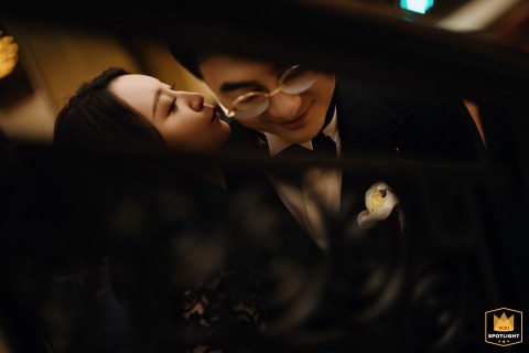 Shanghai Love Story: A Close-Up Embrace at the Peace Hotel Peace Hotel, Shanghai, China. A close-up of a newly-wed couple embracing, viewed through a stair railing.