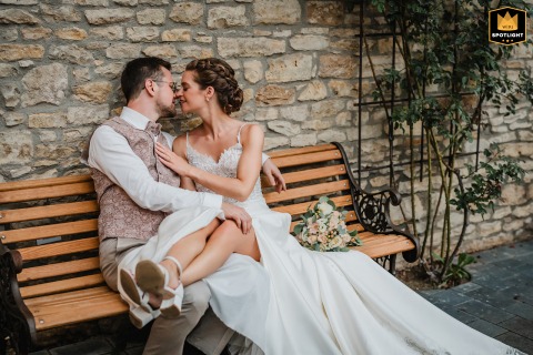 An Ingelheim Idyll: A Newlywed Couple's Quiet Portrait in Germany Relaxed newlywed couple sits on a bench in the courtyard of Kloster Engelthal, Ingelheim, Germany.