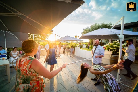 Lively Limbo at Villa Desiderio: An Italian Wedding Party in Motion A wedding party at Ristorante Villa Desiderio in Italy, participating in a lively limbo contest.