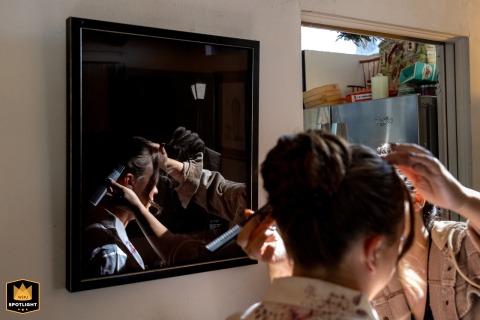 Bridesmaid’s Hair Styling Reflected in Vibrant Los Angeles Artwork Before Wedding Ceremony Bridesmaid getting her hair done in a Los Angeles home, reflected in the vibrant artwork on the wall.
