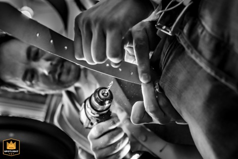 Determined Dutch Groom Drills Belt Hole With Power Tool In Leidschendam Leidschendam, the Netherlands, is where a determined groom takes unique measures to finish getting ready, using a power drill to bore a new, necessary hole in his leather belt.