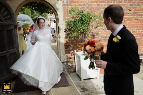 Cambridge Elegance: Hand-in-Hand Through Longstowe Hall Grounds to Wedding Reception Drinks Longstowe Hall, Cambridge, UK, provides the stately grounds as the bride and groom make their way toward their celebratory wedding reception drinks.