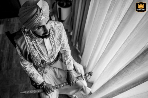 Intimate Calm: Groom Reflecting Alone by Window in Isla Mujeres, Mexico Isla Mujeres, Mexico, provides the intimate setting for the last moments of calm as a groom quietly sits alone near a curtain-covered window, reflecting before his wedding day officially begins.