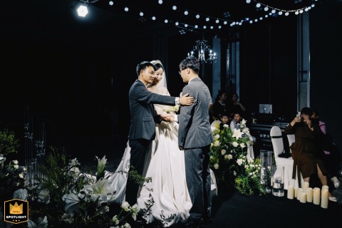 Father Blesses Groom with Hand on Arm in Kaifeng, China Kaifeng, China: The bride's father places his hand on the groom's arm, offering a gesture of blessing and support to the couple during their wedding celebration.