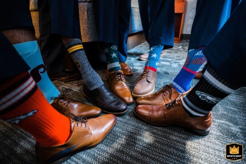 Philadelphia Groomsmen Form Celebratory Circle Showing Bold Socks And Different Shoes In Philadelphia, a group of stylish groomsmen forms a celebratory circle to kick off the big day, showing off their different shoes and bold socks as the same team.