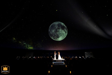 Couple Exchanging Vows Under Moonlight In Franklin Institute Planetarium Philadelphia PA A couple exchanging vows under a moonlit sky inside the Franklin Institute Planetarium in Philadelphia, PA.