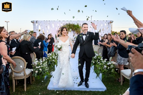 Petals Tossed Over Bride And Groom Exiting Outdoors In Perez Santa Fe Bride and groom exiting outdoors in Perez, Santa Fe, as petals are tossed in the air over them, symbolizing love and celebration.