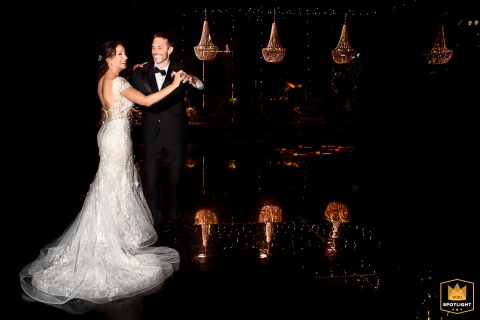 Artistic shot of bride and groom dancing under vibrant light effects in Perez, Santa Fe, Argentina.