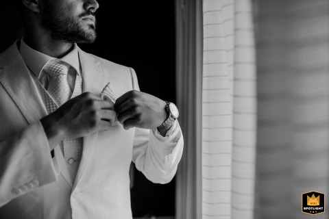 Black and white close-up of the groom adjusting his pocket in Gordes.