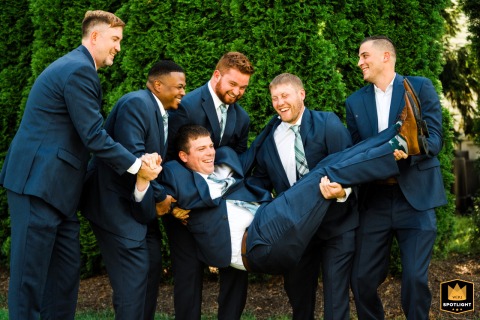 In Philadelphia, Pennsylvania, Groomsmen Lift Laughing Groom for a Moment of Celebration In Philadelphia, Pennsylvania, the groomsmen share a joyful moment together, lifting the laughing groom in celebration.