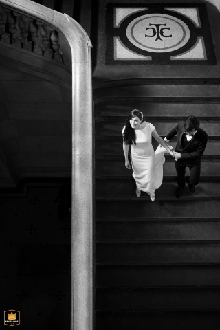 At the Toulouse City Hall in Haute-Garonne, the newlyweds descend the monumental staircase, captured in a black-and-white top-down shot showing the groom holding the bride's dress train.