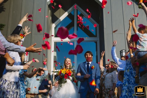 At Tennessee's Grace Point Camp & Retreat Center, guests stand in sunshine, tossing red rose petals over the exiting bride and groom to symbolize a fresh start.