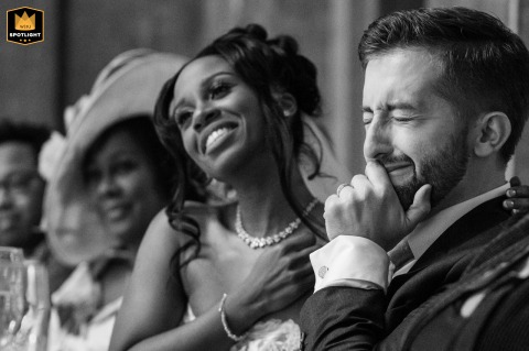 At Fawsley Hall, Northamptonshire, the bride and groom share an emotional reaction during the best man's heartfelt speech. Captured in black and white, their faces reveal genuine love, gratitude, and deep connection in the moment.