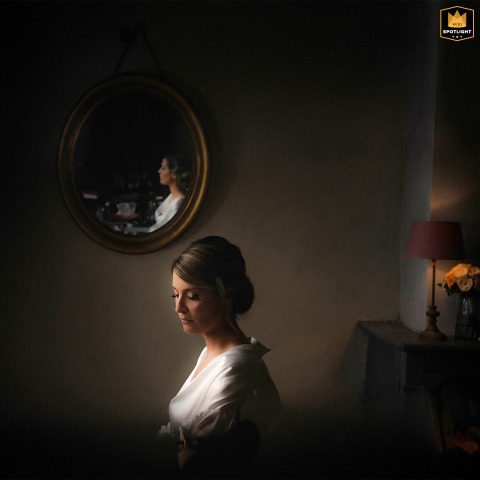 At Chateau de Rossignol in Chalignac, Dordogne, France, the bride sits serenely while having her makeup done. The lighting and composition evoke the timeless elegance of an old-world oil painting by a master.