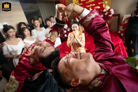 At a hotel in Taiyuan, Shanxi, friends and family enthusiastically play light-hearted games during the wedding procession to welcome the bride, adding laughter, energy, and tradition to the celebratory atmosphere.