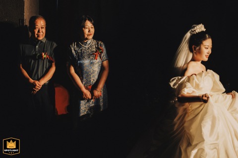 In Kaifeng, Henan, the bride enters, walking past her parents. Her father and mother gaze at her intently, their eyes filled with love and pride as she proceeds down the aisle.