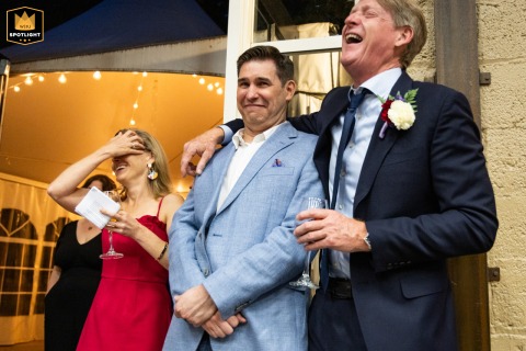   Magnolia Hall in Piedmont Park, Atlanta, fills with laughter as guests enjoy wedding speeches, the joy and celebration palpable throughout the elegantly decorated hall.