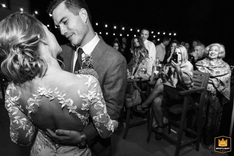   In the backyard of a home in Roswell, Georgia, the couple shares their first dance, surrounded by friends and family beneath the dark evening sky.