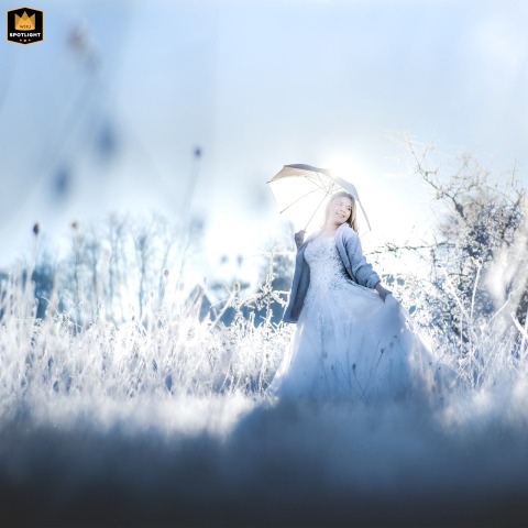   During a winter couple session in Liorac/Louyre, Dordogne, the bride stands cheerfully despite the cold, showing her adventurous side in the chilly French countryside.