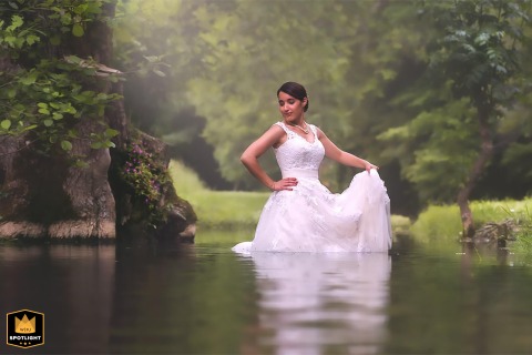 Bride Laughs After Getting Wet During Riverside Session In Dordogne, France Along the Caudeau River in Liorac/Louyre, Dordogne, the bride ends up a bit wet after the couple’s session, adding a playful twist to their romantic riverside adventure.
