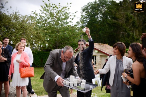   During a backyard ceremony near Normandy, France, a family member, tasked with handing out petals, gets a playful surprise as others dump a few on his head for fun.