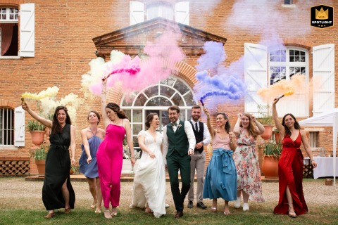 The newlyweds and their witnesses enjoy a lively, colorful smoke grenade walk together at Domaine de Poussignan in Saint-Loube, Gers, infusing the celebration with vibrant energy and fun.