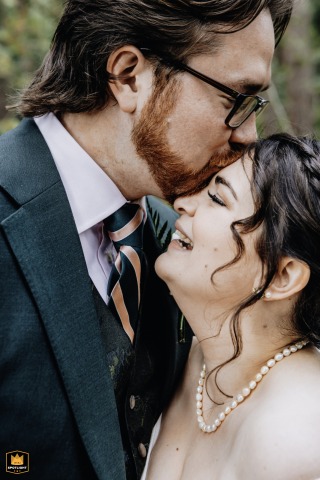   Healey Barn in Northumberland, UK, sets the scene for a gentle, intimate forehead kiss between the couple, reflecting pure affection and closeness.