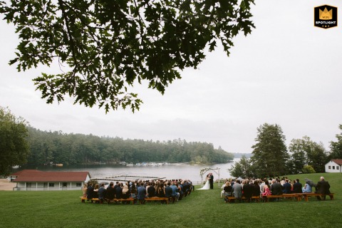   The ceremony on Sebago Lake, Maine, unfolds in a veil of fog, providing a dreamlike lakeside backdrop that highlights the couple’s vows and their unforgettable setting.