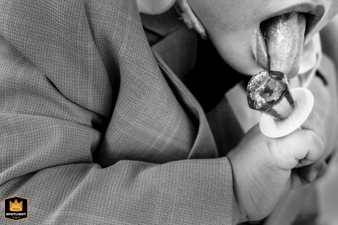   During the ceremony in Zuid Holland, a playful moment unfolds as a young guest can’t resist tasting the ring candy, enjoying the treat in the midst of the celebration.