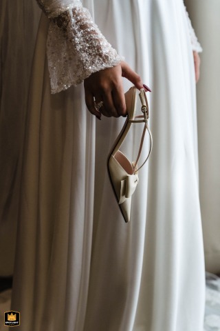Bride Holds Her Shoe In An Elegant Detail Portrait At Columbia Hotel In London A detail shot of the bride holding her shoe at Columbia Hotel in London focuses on the textures and refined elements that bring sophistication to the wedding day.