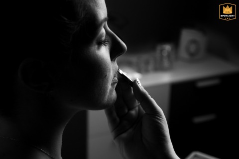   In Gonzaga, Mantova, Italy, a close-up detail of the bride’s lips is beautifully illuminated by window light during her makeup preparations.