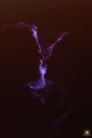   Soft purple lights illuminate the newlyweds' faces during an intimate portrait on the dancefloor at La Factory, Thizy-les-Bourgs, Rhône, France.