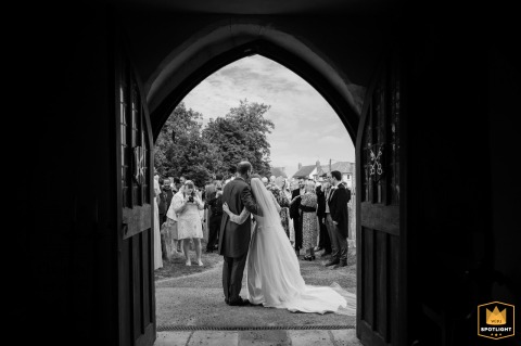   Through the open door of Olney church, there's a warm glimpse of the couple and their guests gathered outside, sharing in the joy after the ceremony.