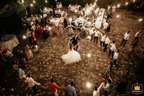 A lively moment unfolds with guests joining hands for a joyful circle dance in Palazzo Marcosanti, Poggio Berni, Italy, reflecting the exuberance and togetherness of the celebration.