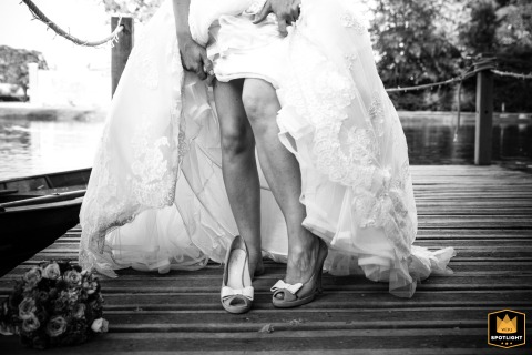 Moments after a boat ride on the lake at Chateau Barthelemy in Yvelines, France, the bride puts on her shoes, combining elegance and adventure in her wedding day routine.