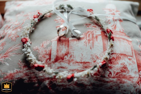 Rings and a delicate headband rest together while the bride gets ready in Yvelines, France, symbolizing cherished elements of both love and preparation before the ceremony.