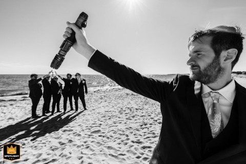 On Bank Street Beach in Massachusetts, the groom throws out a playful challenge to his groomsmen, who respond together, transforming the shore into a scene of fun and shared tradition.