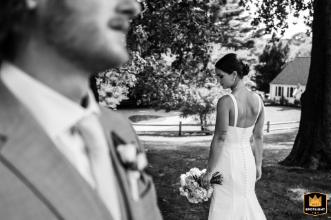 On the grounds of Hoxie House in Sandwich, MA, the bride turns inward just before walking forward, a BW scene filled with both gentle resolve and tender introspection.