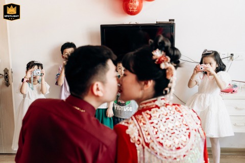 Children eagerly take photos of the newlyweds at home in Fujian, China, delighted to be part of the celebration and capturing joyful memories from their unique perspective.
