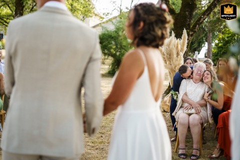 Emotional Portrait Of The Groom’s Mother Being Comforted At Villa Biloba In South Dordogne During the outdoor civil ceremony at Villa Biloba in the south of Dordogne, the groom’s mother is overcome with emotion, comforted compassionately by both his brother and his daughter.