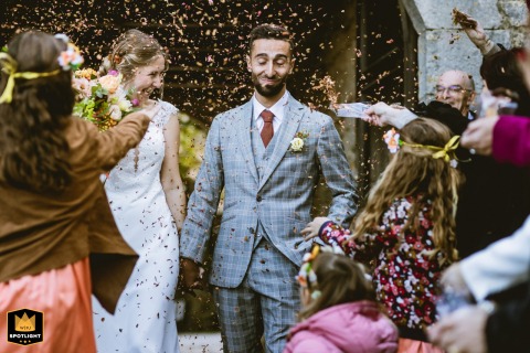 Newlyweds leave their secular ceremony at the Castle of Roussillon in Lot, France as loved ones wait outside, ready to shower them with dried flowers in a festive sendoff.