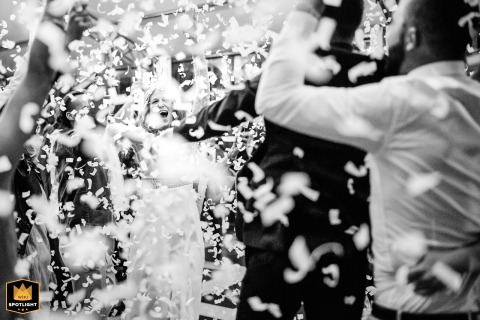 Newlyweds Make A Jubilant Entrance Into The Hall At Domaine De La Fauconnie France Confetti fills the air as the bride and groom make a jubilant entrance into the hall at Domaine de la Fauconnie, their joy shared by guests who welcome them inside.