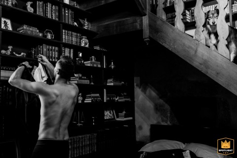 While the groom prepares at the Castle of Roussillon in Lot, France, the family's loyal dog watches him closely, adding warmth to this pre-ceremony moment.