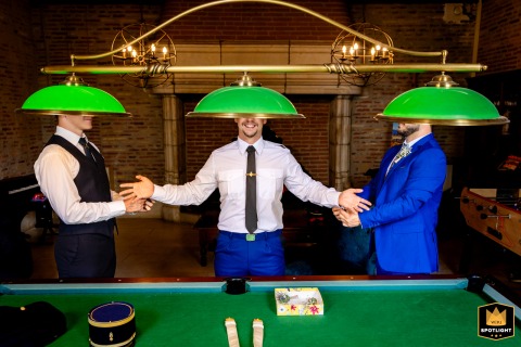 Inside the Domaine de Loubéjac in Tarn-et-Garonne, the groom shares a lighthearted photo session with his witnesses as they prepare together in the billiard room before the ceremony.