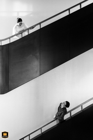 At Neera Retreat Hotel in Thailand, the bride and groom stand on separate stairways, meeting each other's gaze in a vertical shot that beautifully echoes their connection and anticipation.