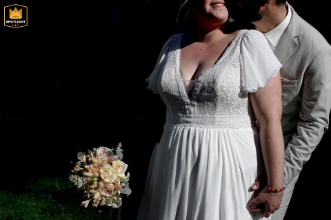 The Newlyweds Pose Together With A Stunning Floral Bouquet During Their Joyful Wedding In France The bride and groom pose together with a stunning floral bouquet, capturing a moment of joy and elegance during their wedding day in the town of Fontaine, France.