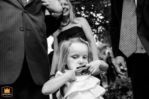 A playful flower girl pulls her mouth wide in response to demands for a big smile during a group photo session at the beautiful Denver Botanic Gardens in Colorado.
