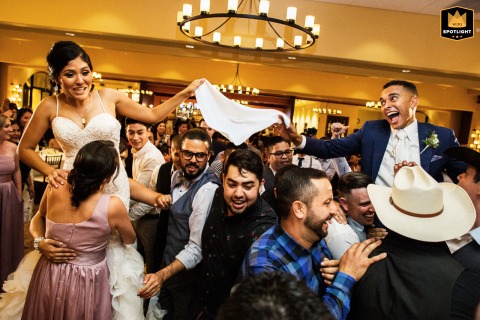 Guests lift the bride and groom above the dance floor at Garré Vineyard in Livermore, California, creating an energetic wedding reception scene filled with celebration and excitement.